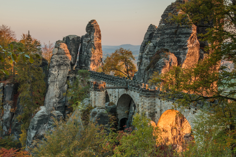 Die Basteibrücke in der Sächsischen Schweiz führt durch Felsformationen hindurch - das malerische Ziel ist perfekt für eine Wochenendreise.
