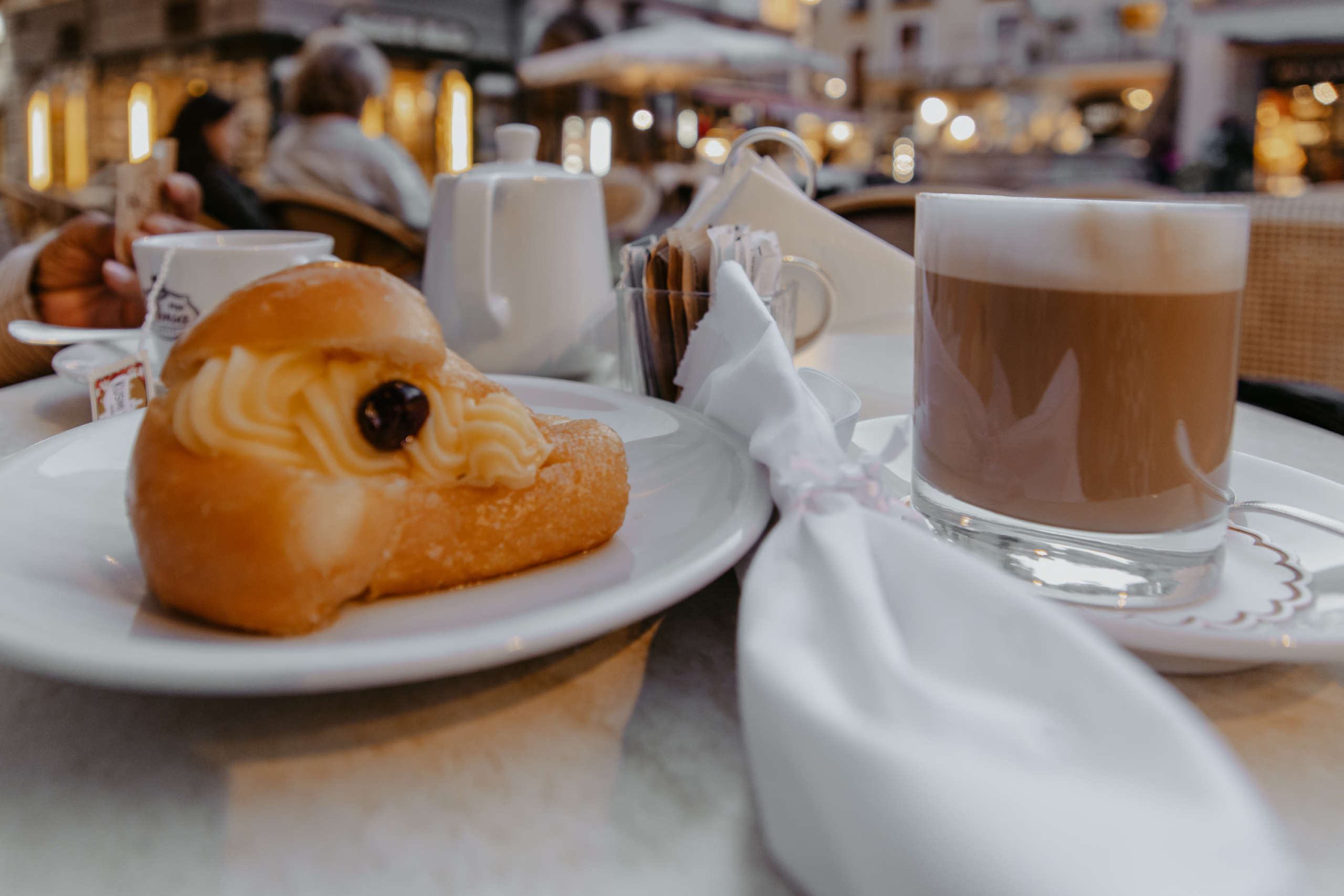 Ein Baba, ein Promille: Die Baba au rhum in der Pasticceria Pansa haben es in sich. Ein Gebäck auf einem Teller mit einem Kaffee.