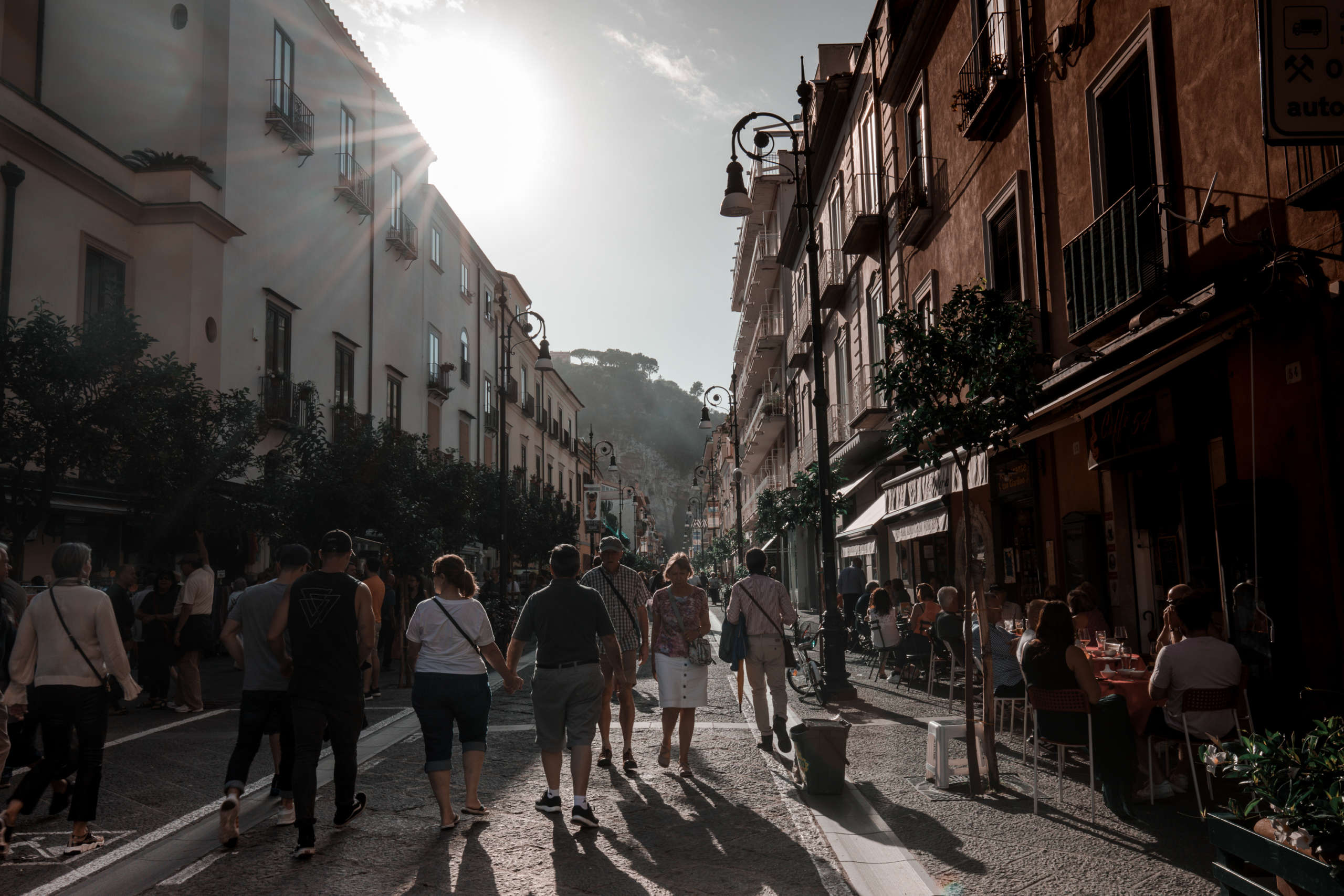 Eine Gasse mit vielen Menschen und bunten Häusern.