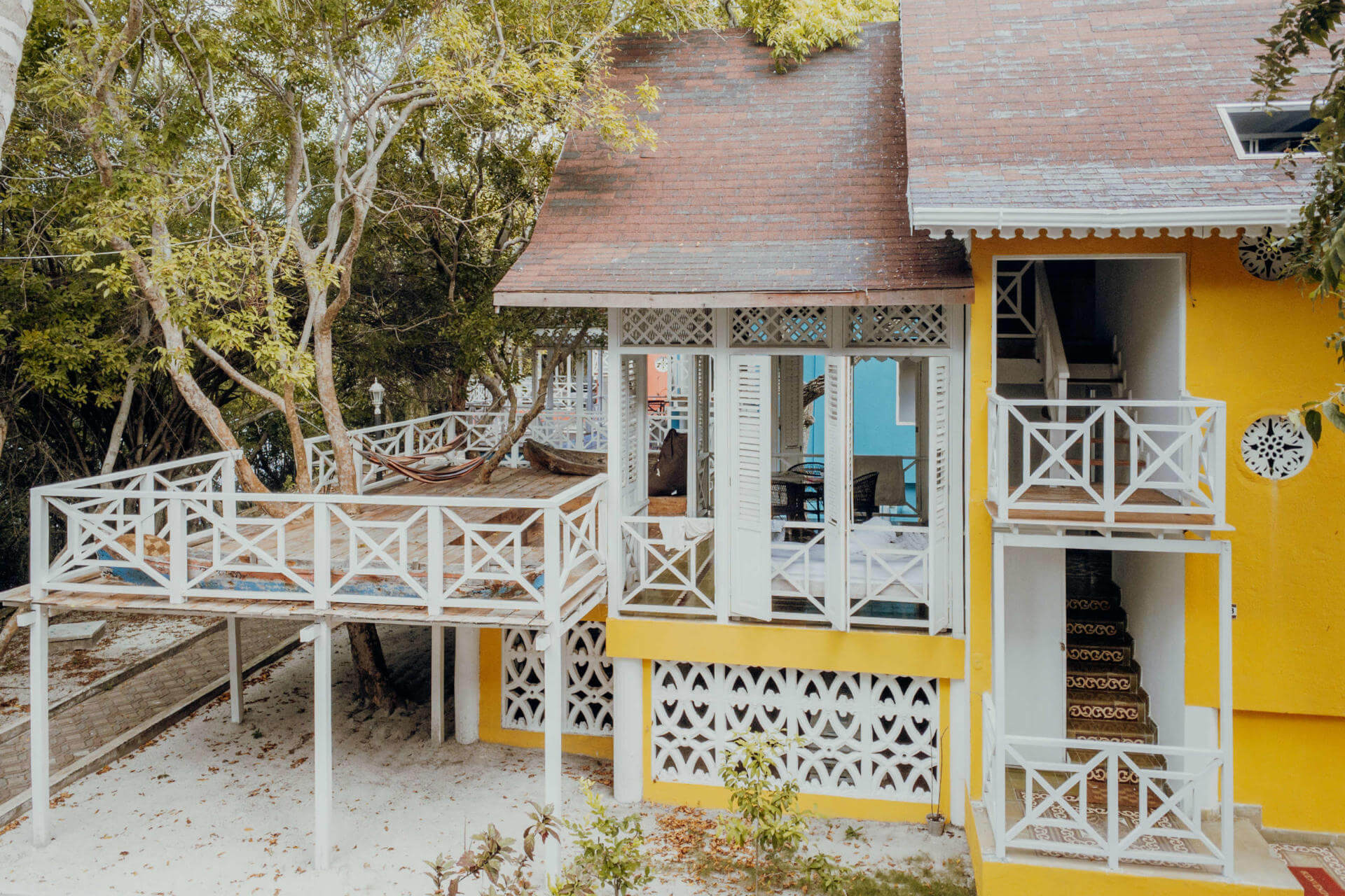 Be guests in the former luxury summer villas of local emerald barons. A yellow house with a large balcony.