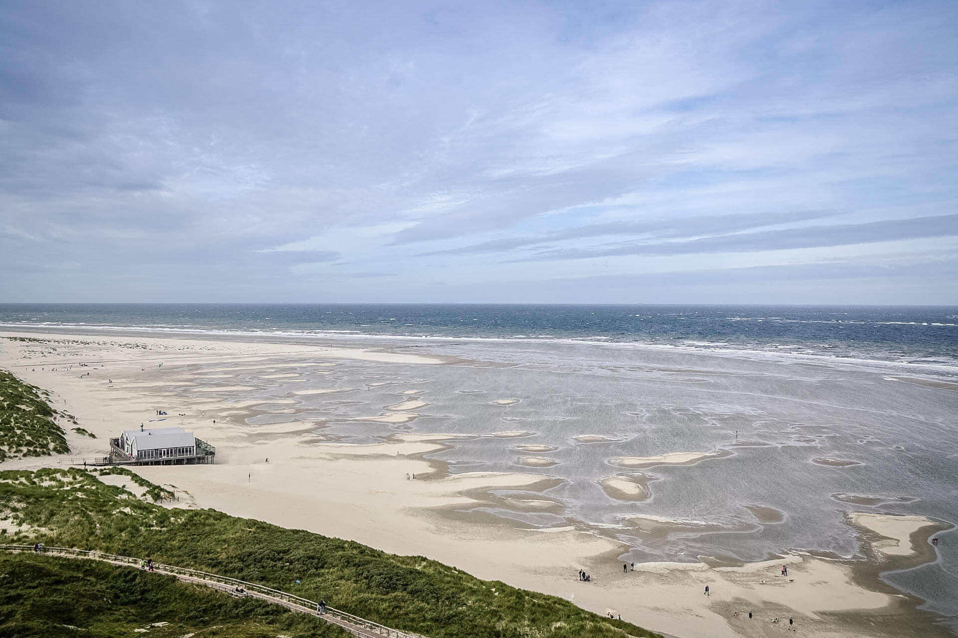 Blick auf einen niederländischen Strand und die Küste, im Hintergrund der Himmel