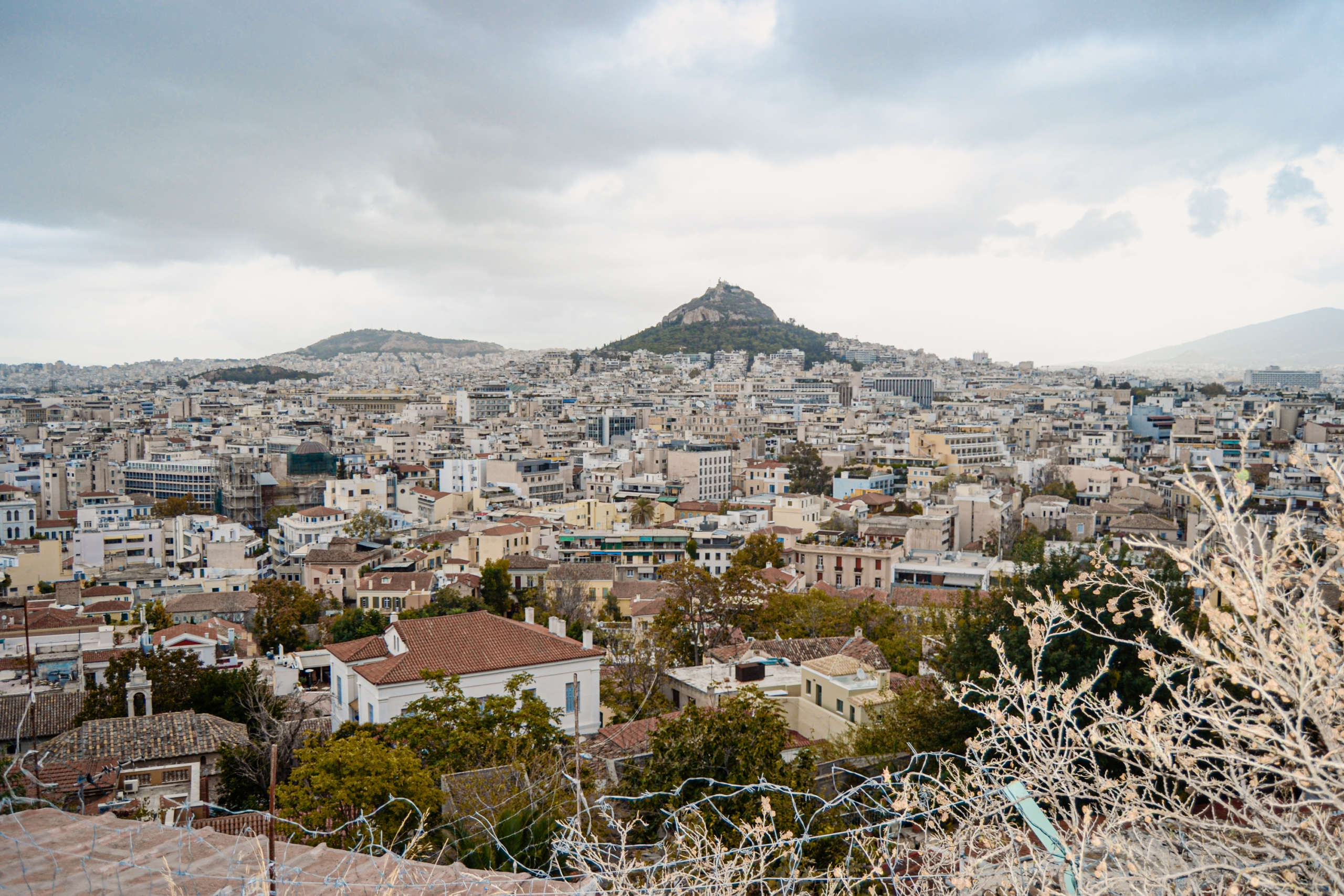 Skyline von Athen, Blick über Häuser und einen Berg i Hintergrund.