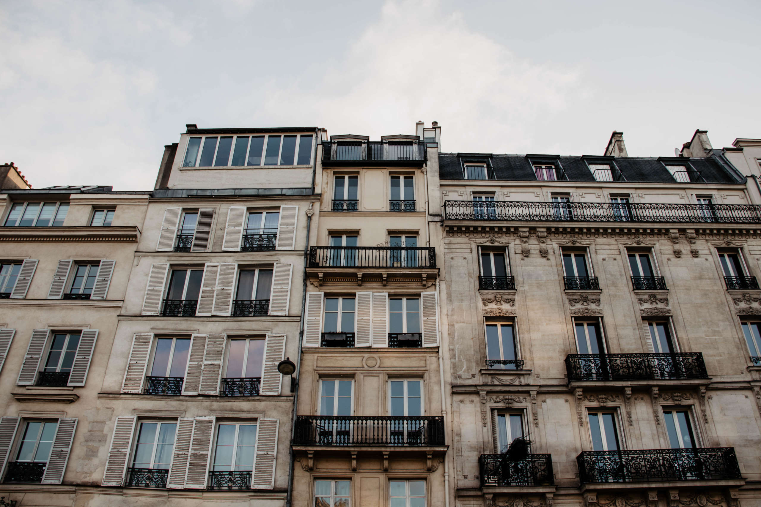Imposanten Häuserfassaden mit verschnörkelten Balkongeländern begegnen Besuchern an vielen Ecken in Paris.