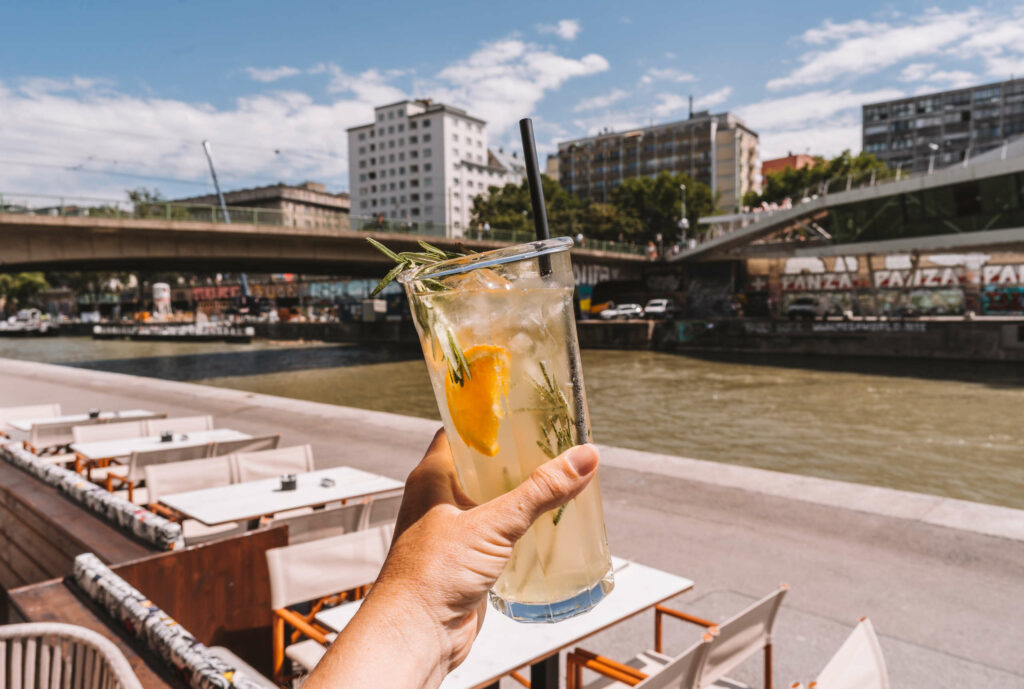 Mit einem Glas frischer Limonade in der Hand erholt sich Bloggerin Melanie in einem Café am Donaukanal von ihrer Tour durch Wien.