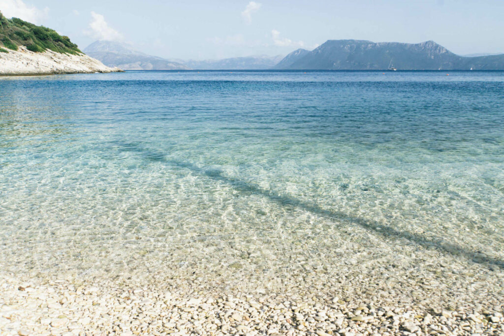 Glasklares Wasser am Kiesstrand von Meganisi, der kleinen Nachbarinsel von Lefkada im Ionischen Meer.