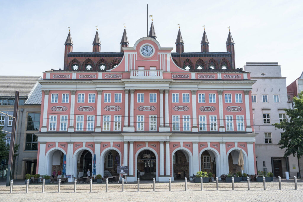 Das Rathaus von Rostock mit seiner rosafarbenen Fassade ist eine berühmte Sehenswürdigkeit der Stadt.