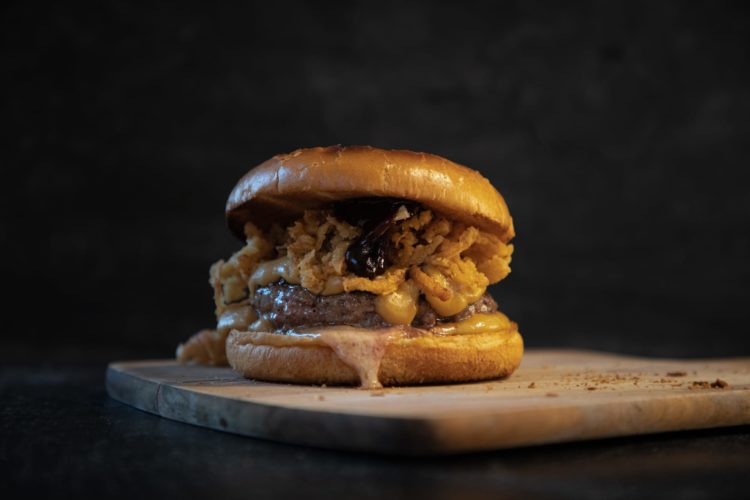 Amerikanische Blaukäse-Whisky-Burger mit schmelzender Sauce und allerlei weiteren Zutaten.