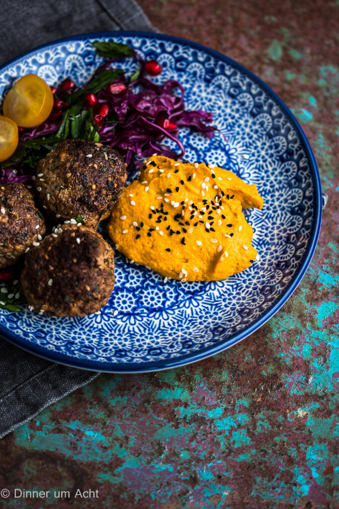 Ein beliebtes Rezept aus dem Nahen Ost sind Lamm-Minzbällchen mit Kürbishummus und Granatapfel-Rotkohl-Salat.