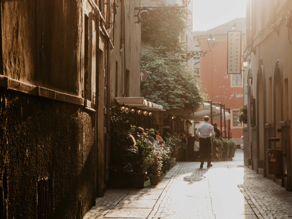 Sonnenlicht taucht eine enge Gasse in Italiens noch recht unbekannter Stadt Parma in helles Licht.