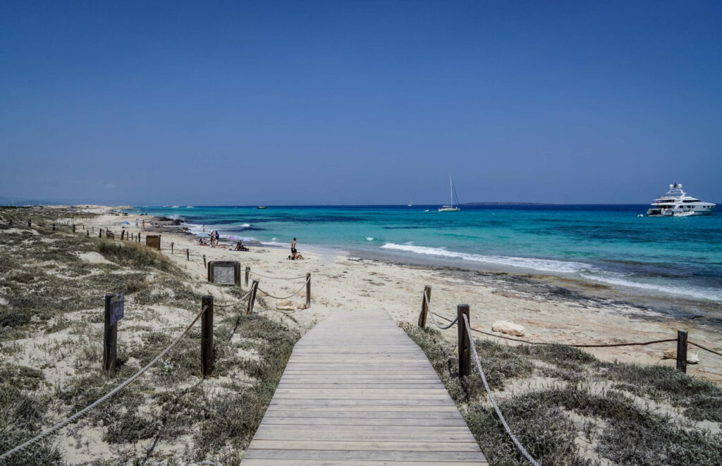 Ein Holzweg führt an einen unberührten Strand von Formentera.