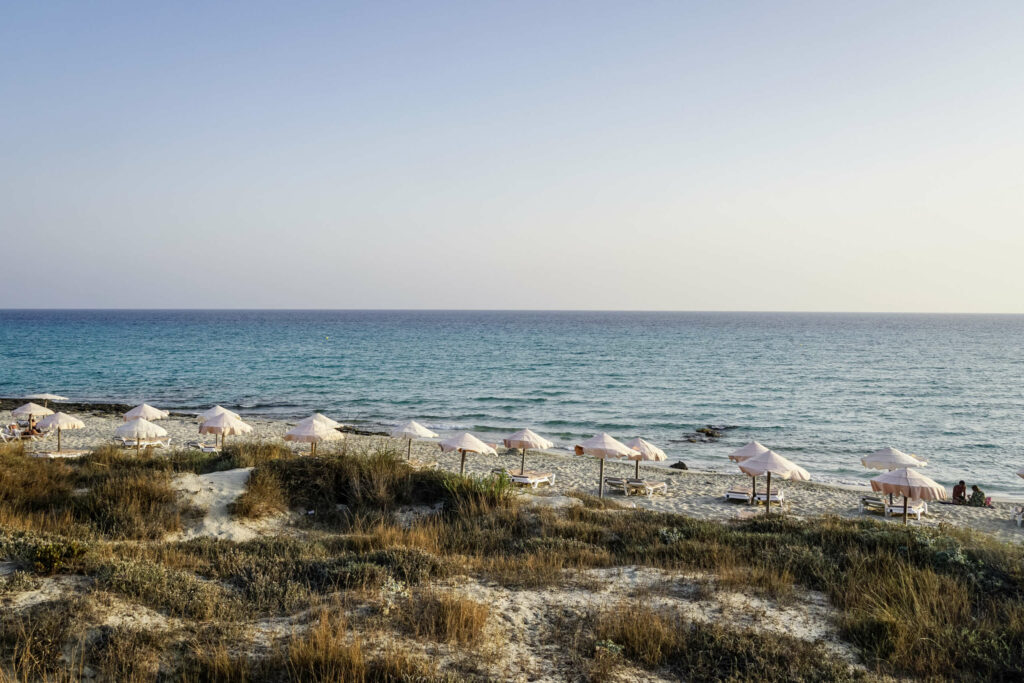 Die Strände von Formentera liegen malerisch in wunderschönen Buchten mit weißen Schirmen - die Insel ist noch ein echter Geheimtipp.