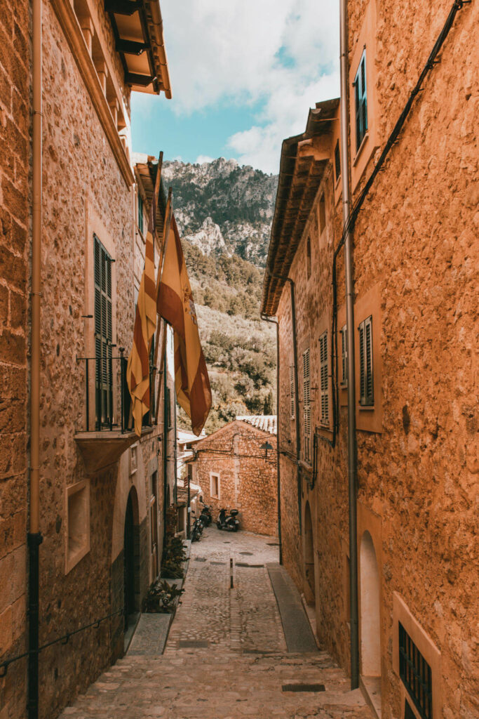 Blick durch eine kleine Gasse in Mallorcas ruhigem Ort Fornalutx auf die Berge der Tramuntana.