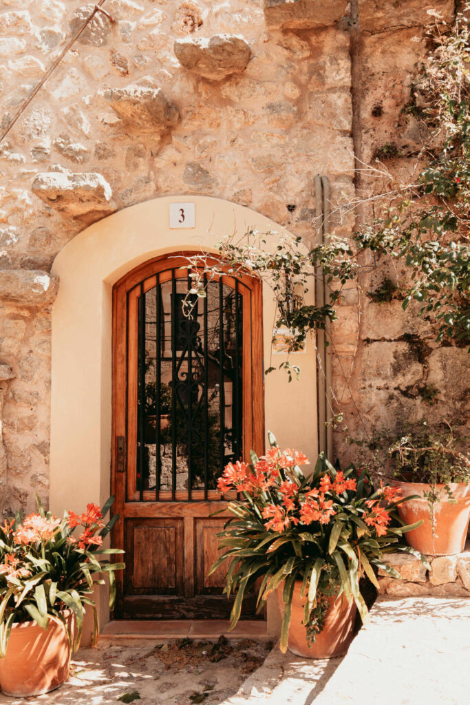 Eine mit Blumen geschmückte Tür in der Altstadt vom schönen ruhigen Ort Valldemossa auf Mallorca.