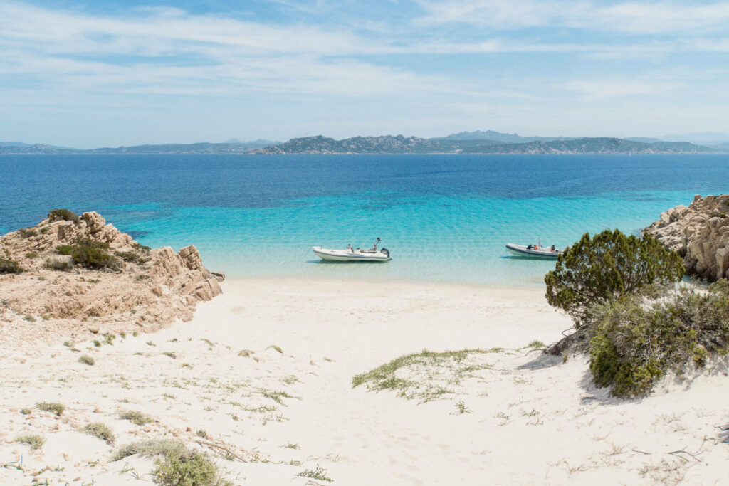 Einige Boote schwimmen auf dem klaren Wasser im Norden von Sardinien.