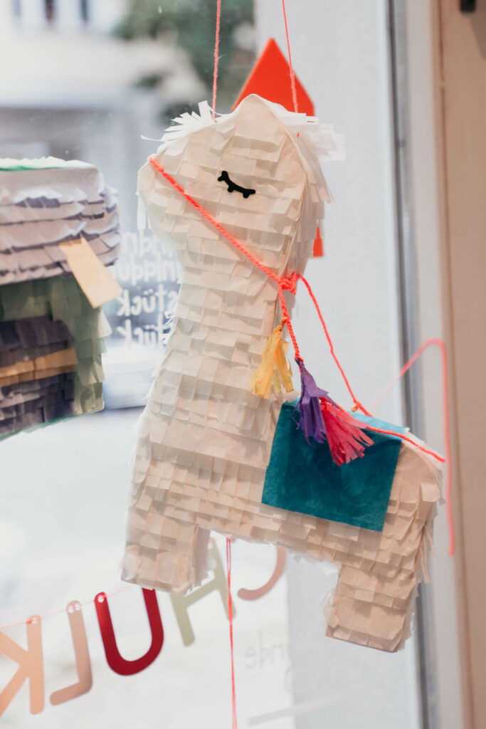 Eine Pinata hängt bei einLaden in Berlin am Fenster.