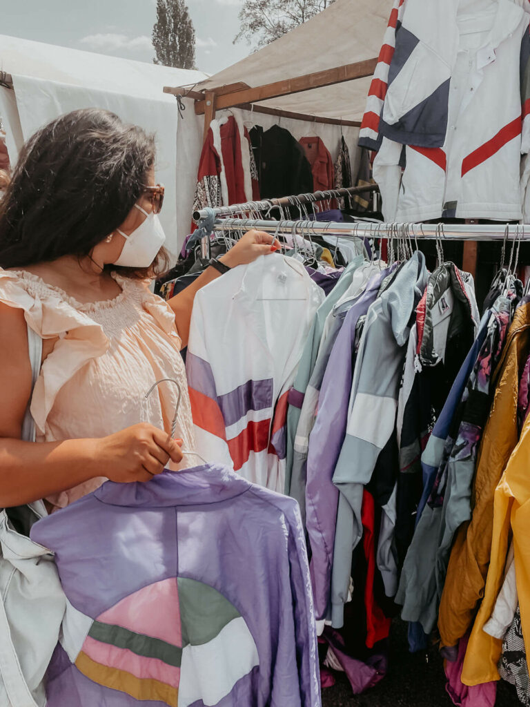 Tatiana von TheHappyJetlagger shoppt vintage Kleidung auf dem Mauerpark Flohmarkt in Berlin.