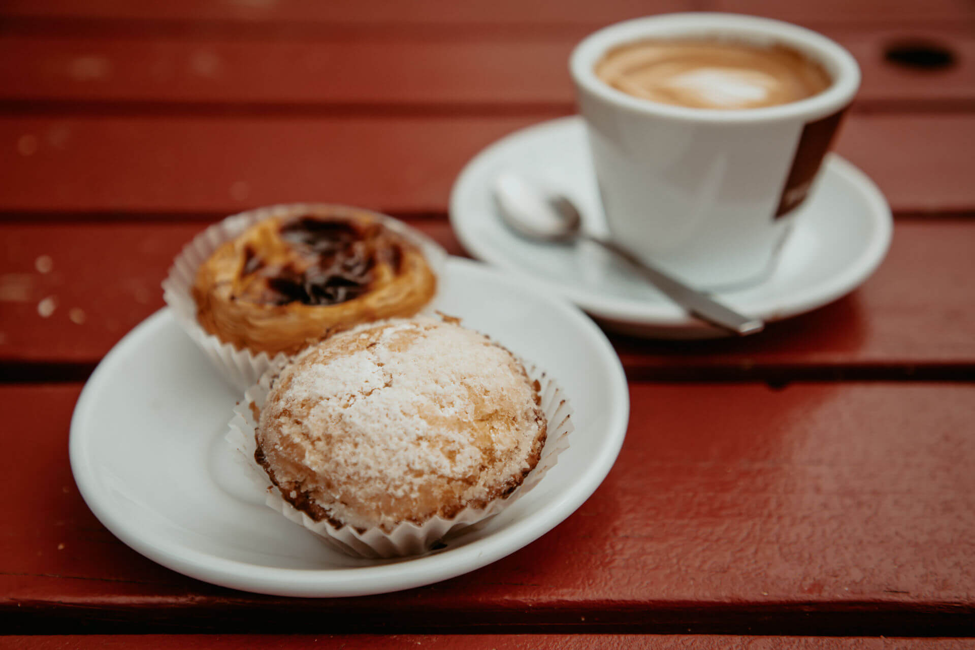 Die Pasteis mit Capucchino im Unser Café im Szeneviertel Prenzlauer Berg, Berlin sollte man als Besucher auf jeden Fall probieren.
