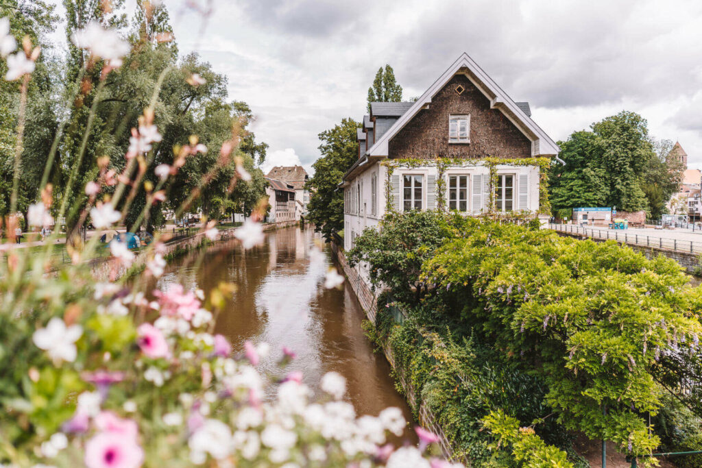 Das Rathaus von Strassburg liegt direkt am Fluss und wird von schönen Büschen und Blumen geschmückt.