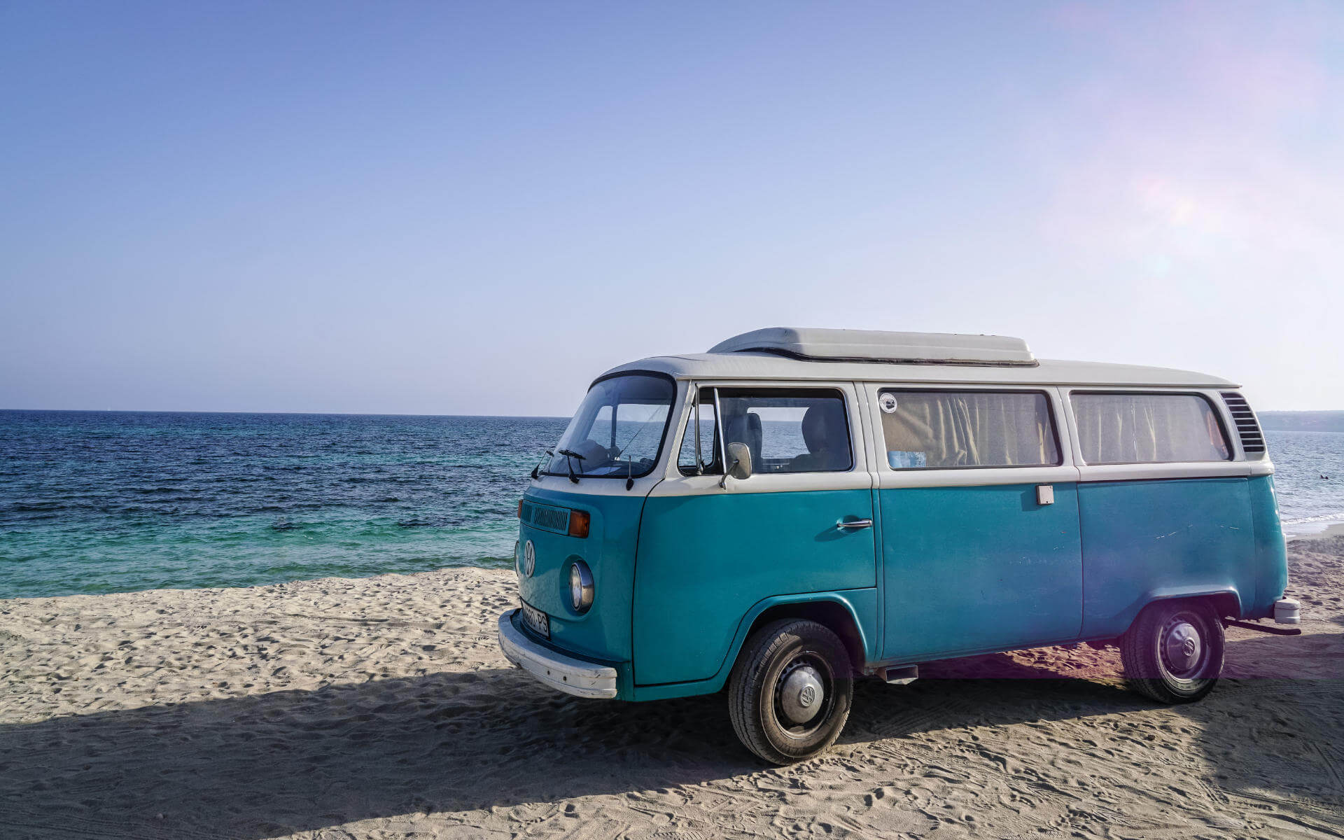 Am Playa de Migjorn auf Formentera steht ein alter blauer VW Bulli - die Hippiekultur der Insel sollte man gesehen haben.