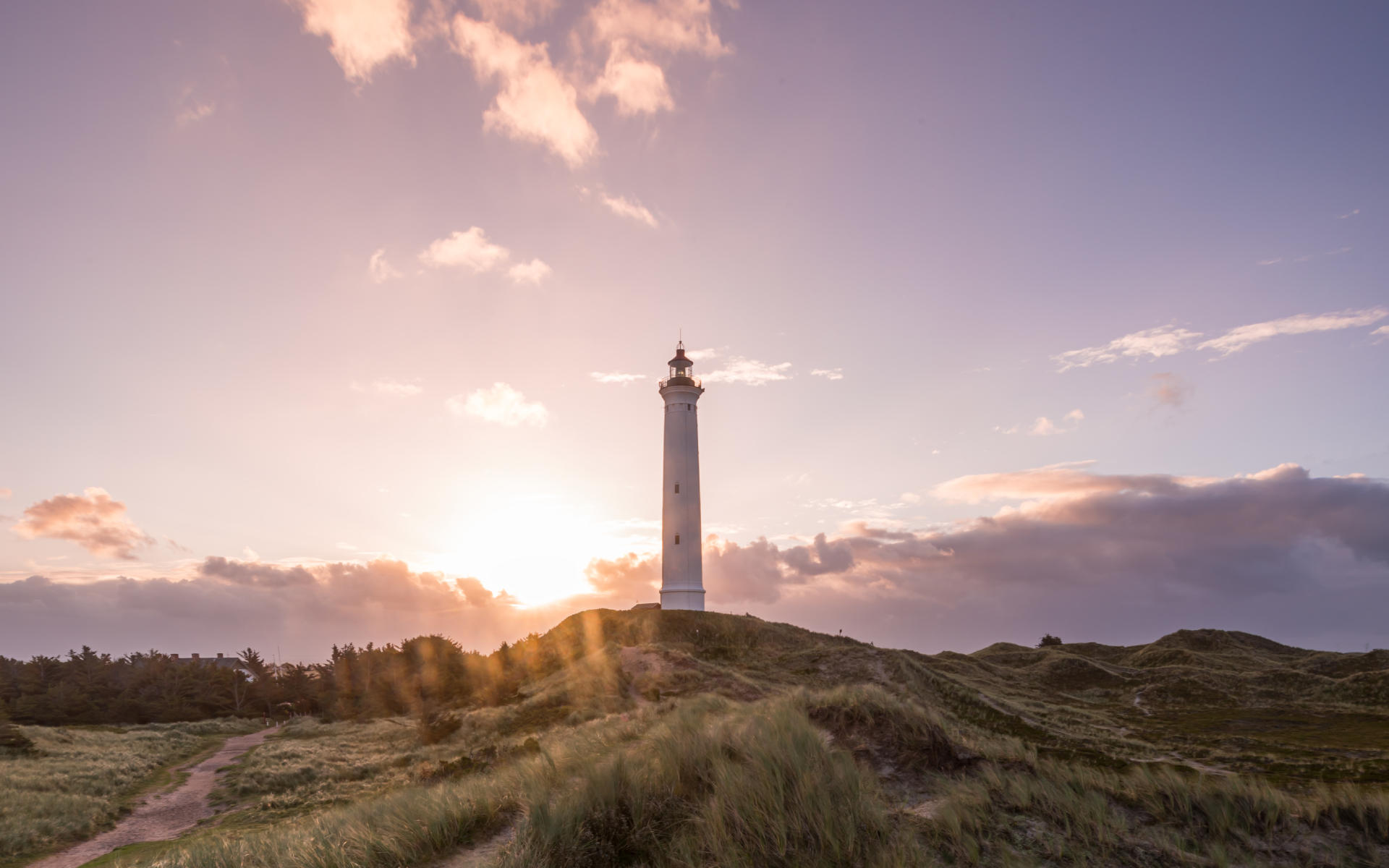 Eine wunderschöne Sehenswürdigkeit in Dänemarks Natur: Der Leuchtturm Lyngvig Fyr, besonders vor dem lila Himmel bei Sonnenuntergang.