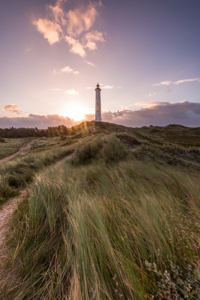 Eine wunderschöne Sehenswürdigkeit: Der Leuchtturm Lyngvig Fyr in Dänemark, besonders vor dem lila Himmel bei Sonnenuntergang.