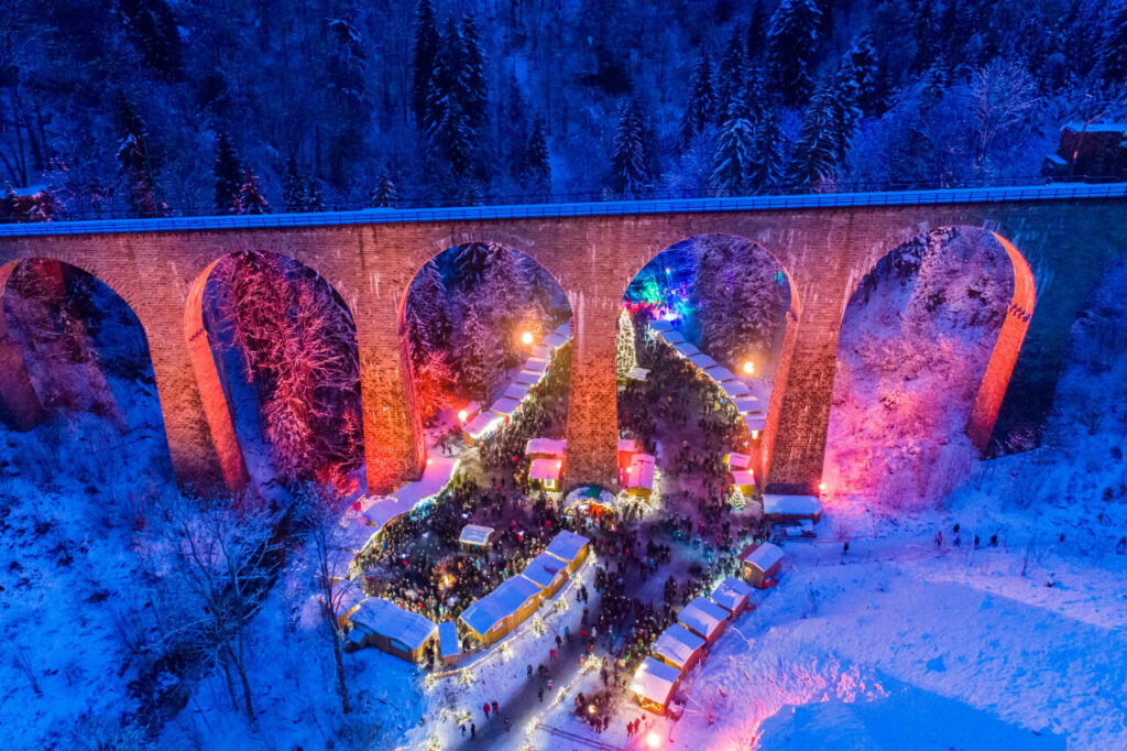 Ein außergewöhnlicher Weihnachtsmarkt in Europa: Über dem Weihnachtsmarkt in der Ravennaschlucht verläuft ein gut 40 Meter hoher Viadukt entlang.