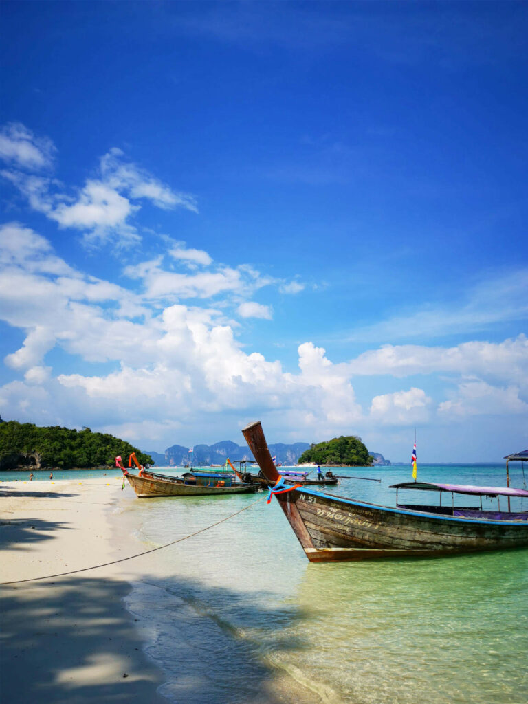 In Thailand kommt man am besten mit Longtailbooten auf die Inseln und genießt dabei die Aussicht auf des Meer.