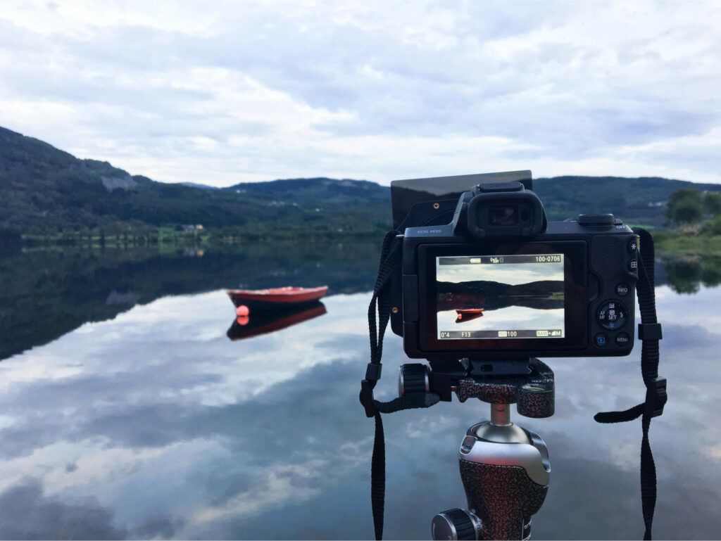 Reisefotografie mit einer Einsteigerkamera an einem See in Norwegen, auf dem ein Boot schwimmt.