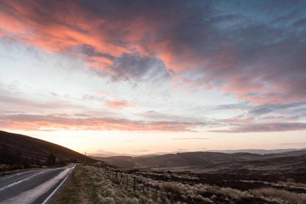 Eine Straße zum Sonnenuntergang in Schottland.