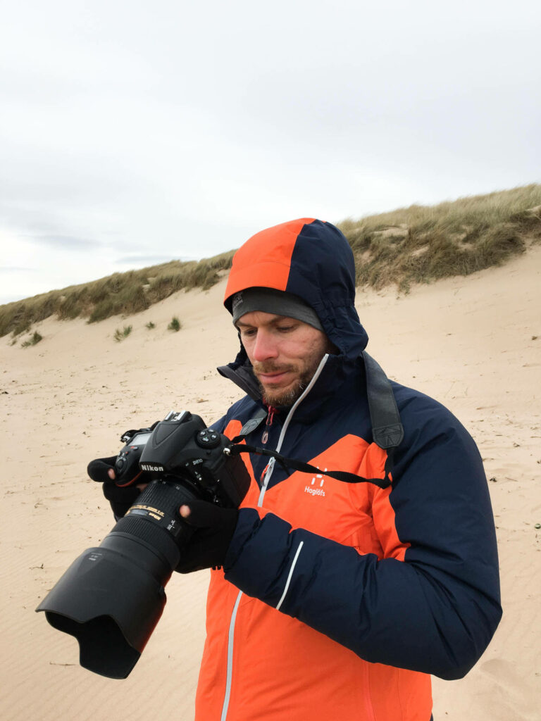 Florian schaut bei der Reisefotografie auf das Display seiner DSLR.