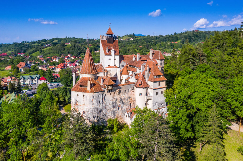 Draculas Schloss umgeben von Bäumen ist eine Reise nach Rumänien wert.
