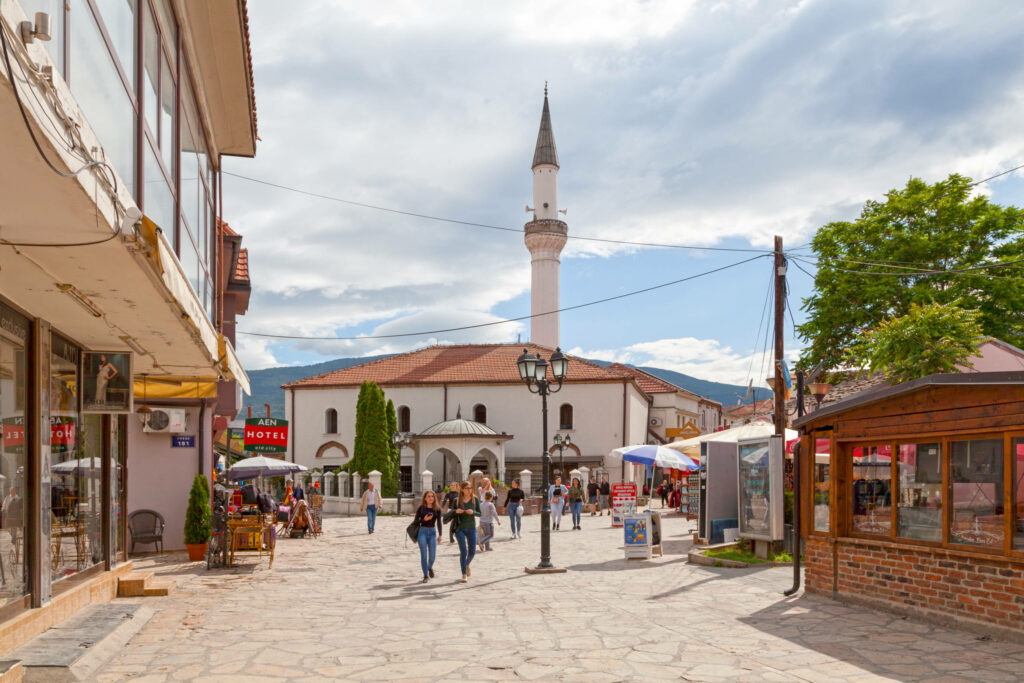 Ein belebter Platz mit einer weißen Moschee in Nordmazedonien.
