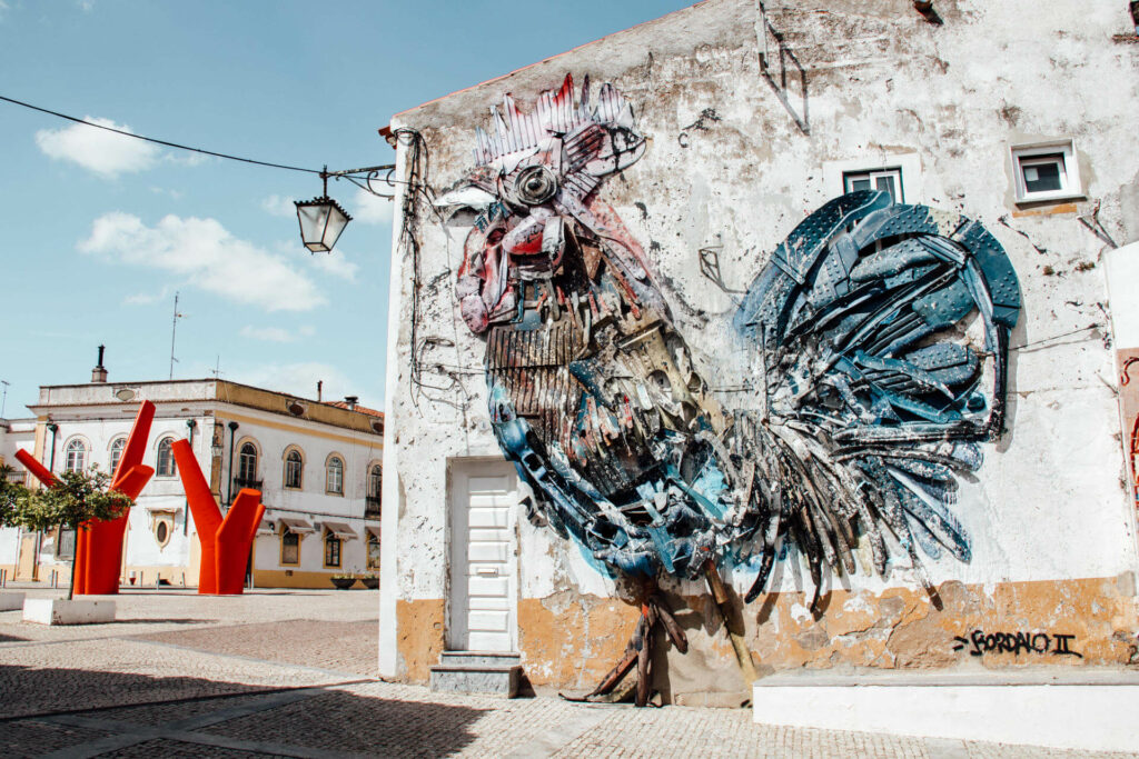 Ein riesiger künstlerischer Hahn verziert die Wand eines Gebäudes. Eine Sehenswürdigkeit von den Straßen des Alentejos.