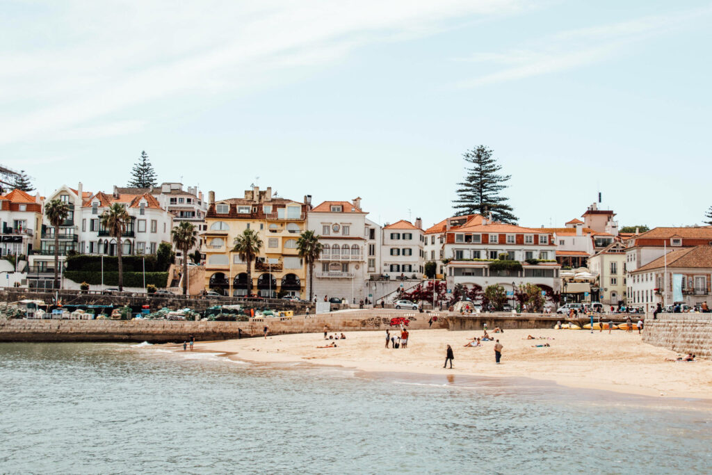 Einer der schönsten Orte: Badestrand mit Palmen und portugiesischen Häusern im Hintergrund