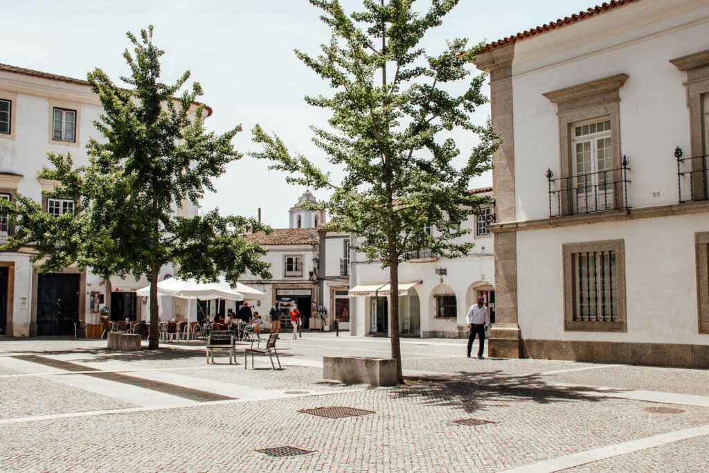 Ein schön gepflasterter Platz mit einem Außenbereichs eines Cafés in der Altstadt in Evora im Alentejo.