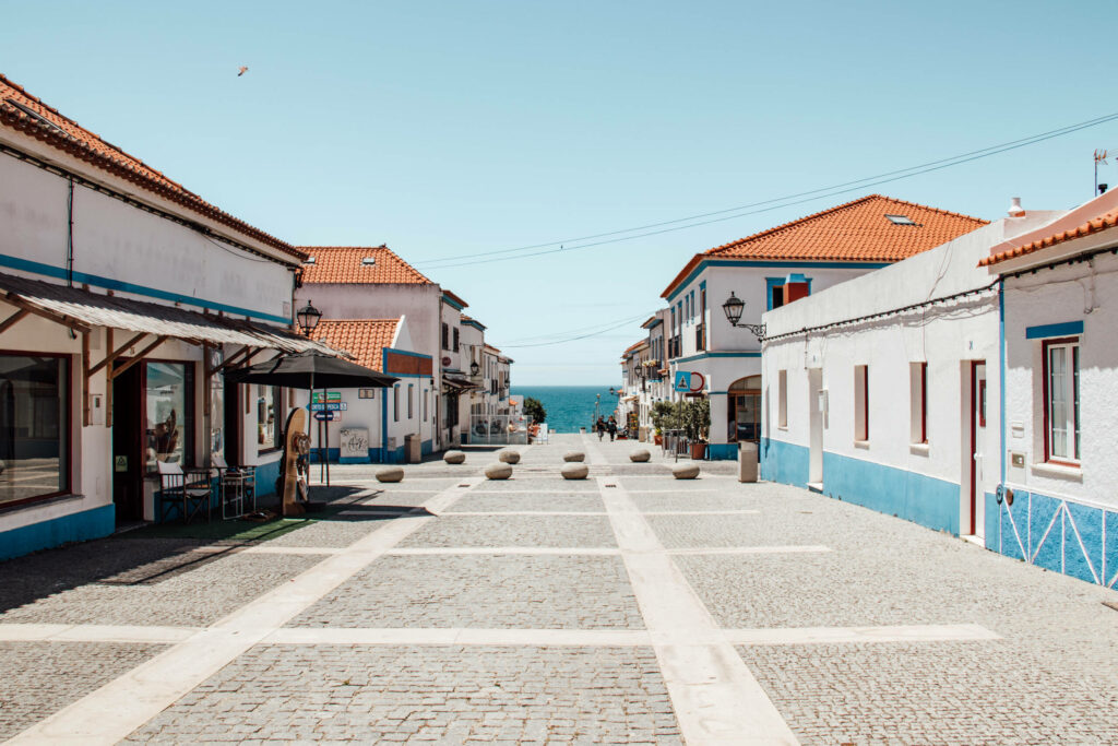 Kleine Straße mit Häusern im portugiesischen Stil hin zum Meer an der Algarve
