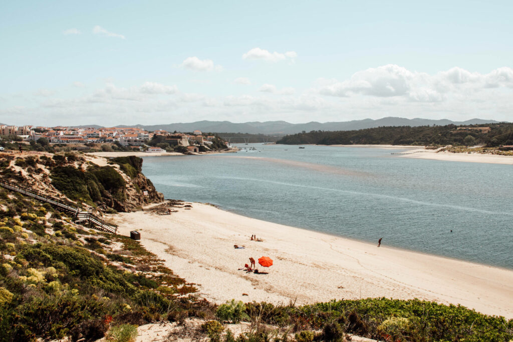 Ein roter Sonnenschirm als Farbklecks am traumhaften Strand