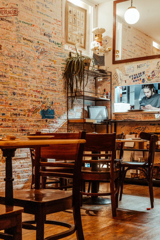 Den kleinen Raum der Tapas Bar La Pepita zieren schlichte Holzmöbel und bute Möbel.