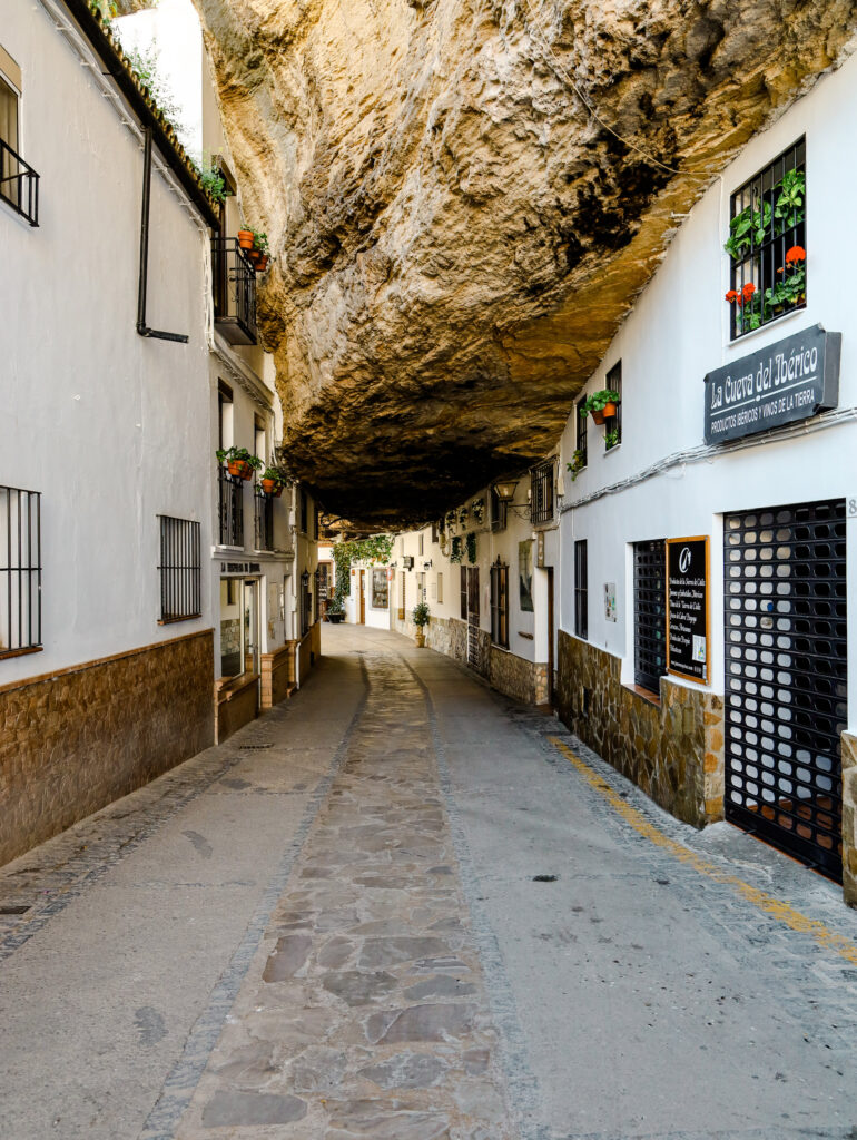 Ein spektakuläres Reiseziel ist das weiße Dorf Setenil de las Bodegas, bei dem Mitten in der Gasse ein Fels rausrakt.