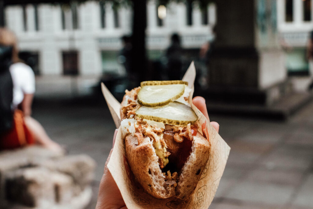 Bei einer Städtereise nach Kopenhagen darf ein leckerer Hot Dog mit Röstzwiebeln und Gurkenscheiben nicht fehlen.