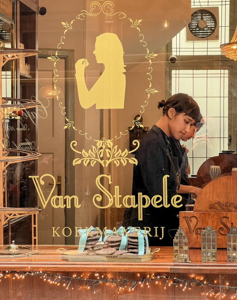 Der Blick durchs barock verzierte Schaufenster gibt Einblick auf den Keksladen in Amsterdam.