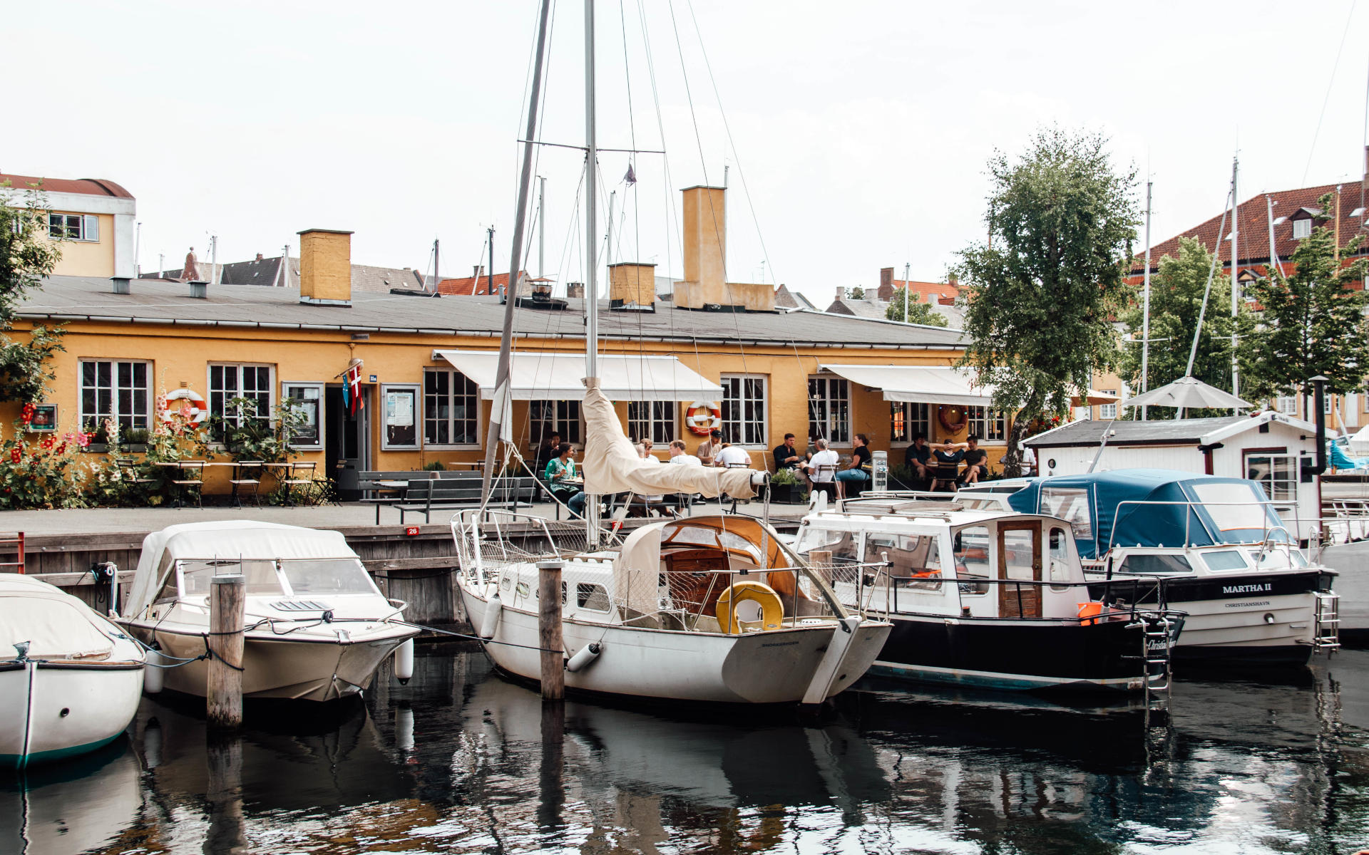 Im Wasser spiegeln sich die Boote, die in Kopenhagen angelegt haben.