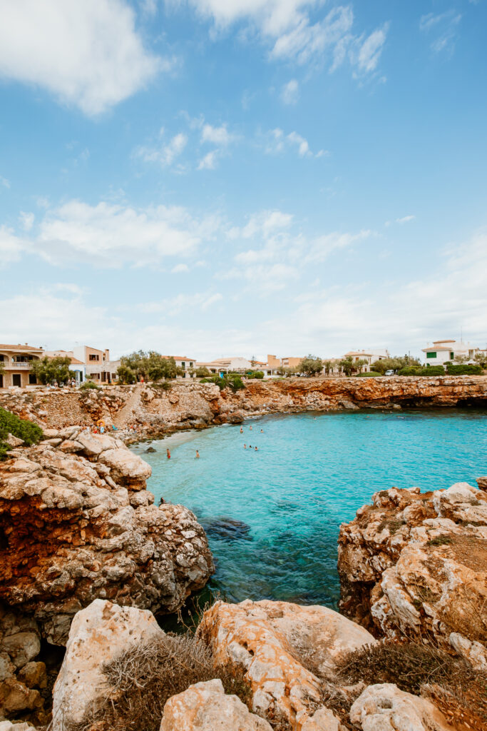 In der Bucht Cala Morlanda umfassen felsige Vorsprünge das türkisblaue Meer.