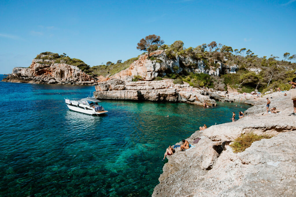 Die felsigen Steinausbuchtungen in der Bucht Cala s’Almunia führen direkt ins tiefblaue Meer.