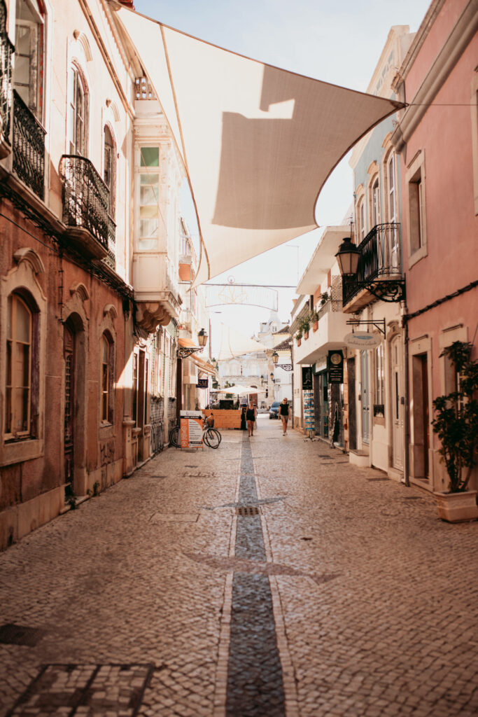 Eine ruhige Nebenstraßen in Faro, geschückt mit weißen Segeln die zwischen den Häusern hängen.