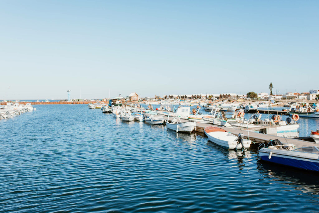 Den Hafen auf der Ilha Culatra in Faro schmücken Boote und blaues Wasser.