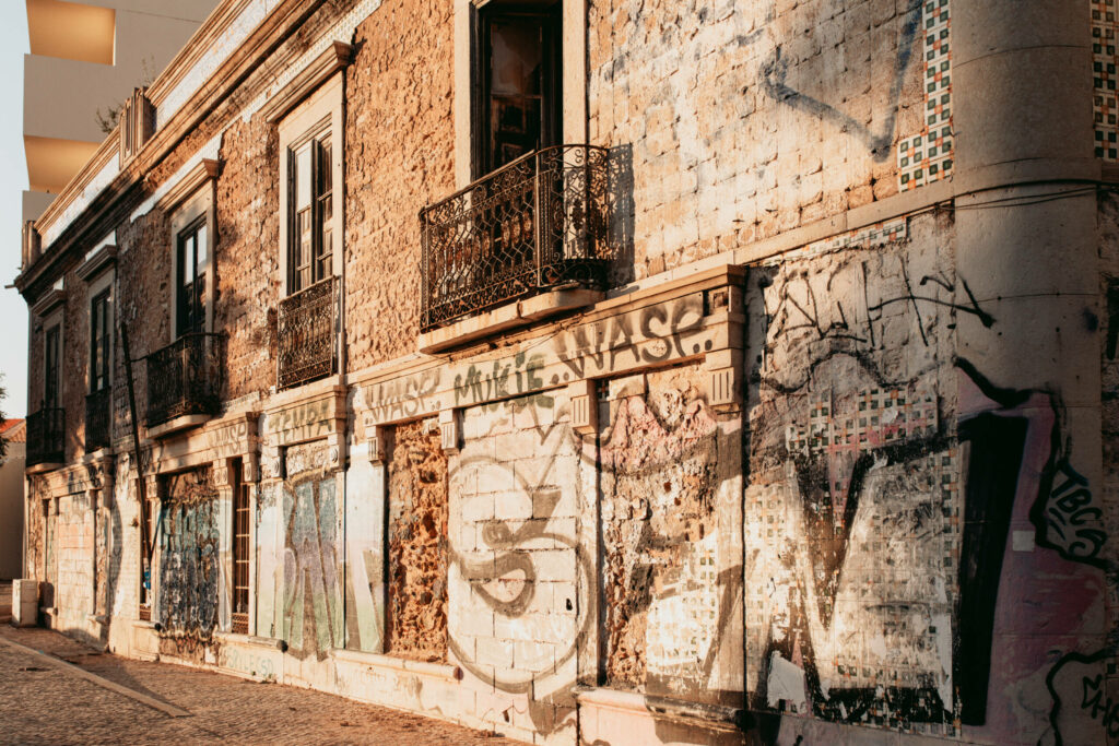Ein leerstehendes, altes, steinernes Gebäude in Faro mit Graffitis besprüht.