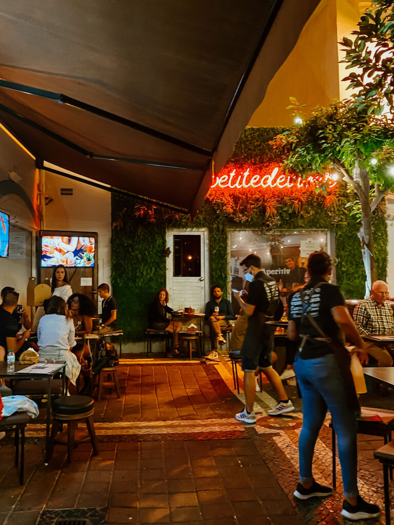 Menschen sitzen abends im freien an Tischen eines Restaurants in der Altstadt von Faro.