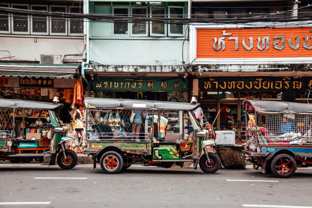 Ein vollbeladenes Tuk Tuk in einer typischen Straße in Bangkok. Ein Geheimtipp Bangkoks, um von einem Stadtteil nach ans andere Ende der Stadt zu kommen.
