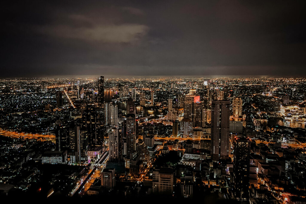 Die hellerleuchteten Gebäude und Straßen in der Nacht von Bangkok.